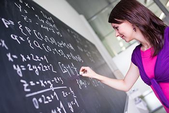 A girl solving function on a black board