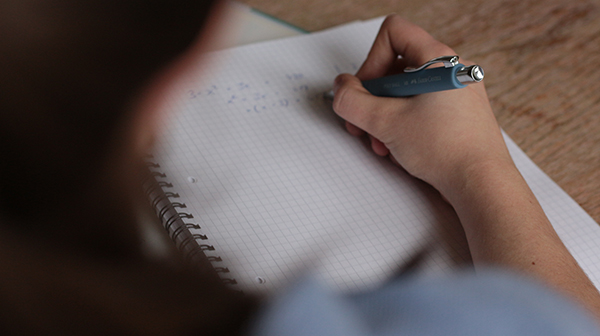 a girl solving equations in her notebook