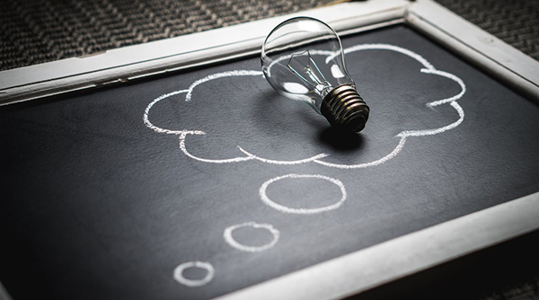 A lightbulb and thought bubble on a slate board