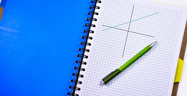 a notebook, pen, and graph