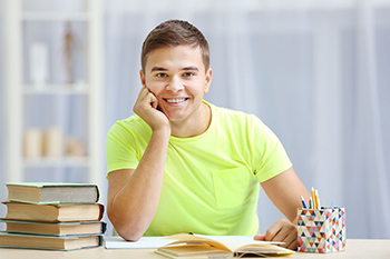 male student doing work at a desk