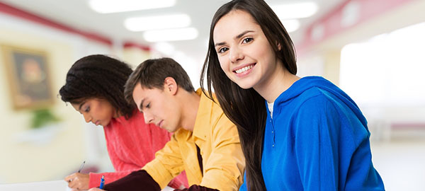 three teens in a classroom taking a exam