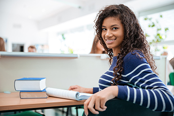 A student at a desk smiling