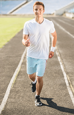 male student running on a track