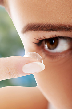 Young woman inserting contact lens