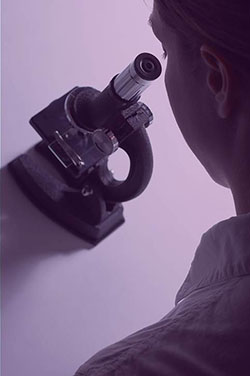 student with microscope