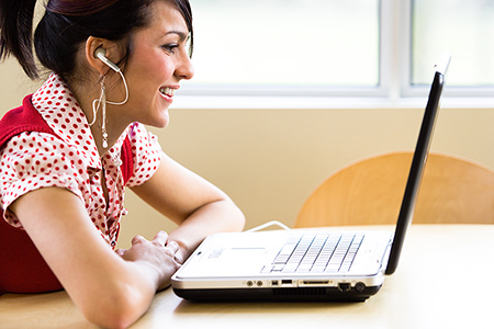 Student with headphones at a computer