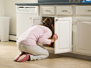 Girl looking under the sink