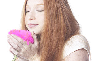 Girl smelling a pink flower