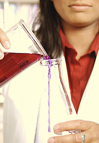 Chemist pouring liquid into a flask