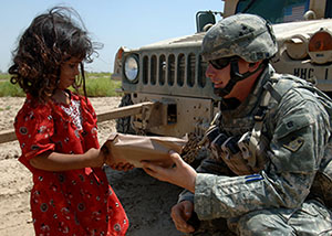 Solider giving an Iraqi girl an MRE