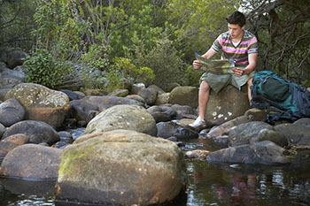 Man sitting on a rock with a map