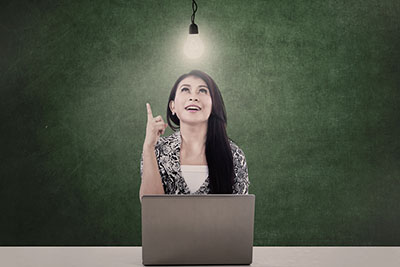 A girl pointing towards a light bulb