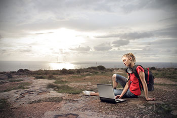 A girl studying rocks with a laptop