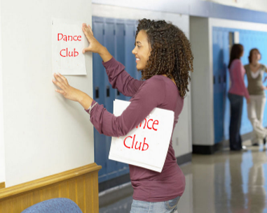 Girl putting up a Dance Club flyer on the school wall