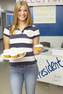 Student running for class president, offering a cupcake