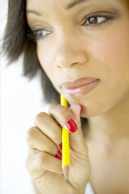 Girl holding pencil, thinking