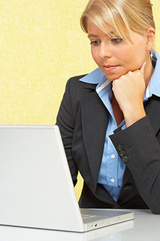 female student using computer and thinking