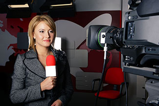 reporter standing in front of a camera