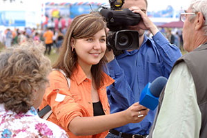 female reporter holding a microphone to a witness with a cameraman