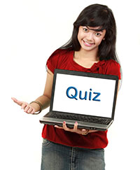 female student holding laptop with the word "Quiz" on the screen