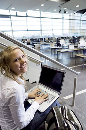 student typing on laptop