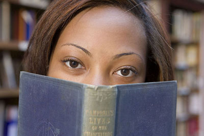 female student looking over book