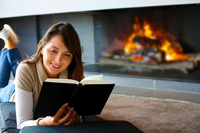 girl reading by the fireplace