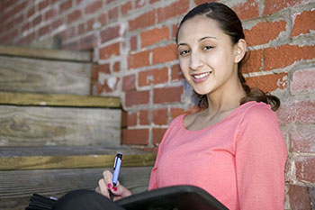 female student writing in journal