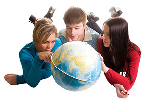 three students looking at a globe and thinking