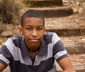 African-American male student sitting outside with determined look