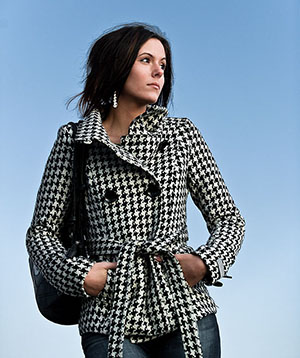 girl with black and white jacket thinking with blue sky backdrop