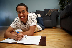 boy writing and smiling