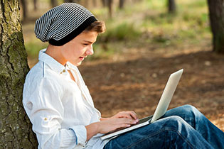 student sitting outside using a laptop