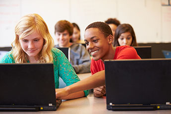 students researching on laptops