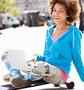 smiling girl with a skateboard and laptop