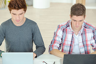 students writing on laptops