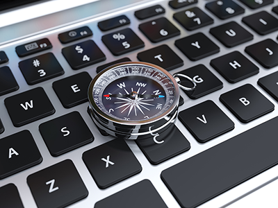 A compass sitting on a computer keyboard