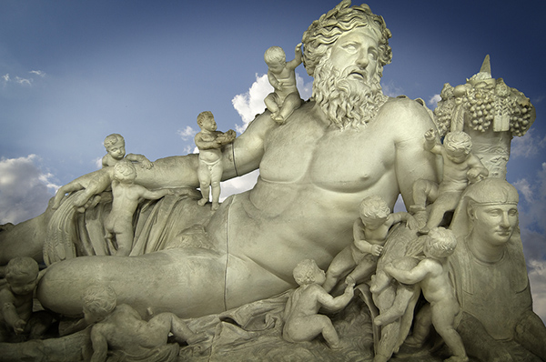 Statue of Zeus propped up on his side with ten of his children surrounding and on top of him