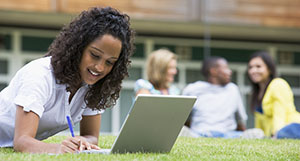 Girl working outside on a computer