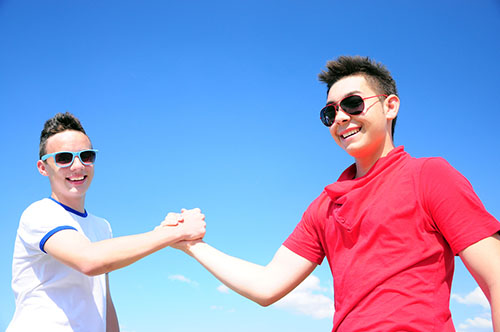 two male teens embracing each other's hands