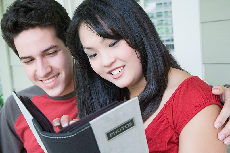 a male and female looking at a photo album