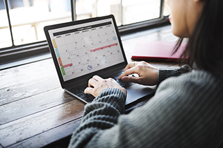 Student creating a schedule on a laptop