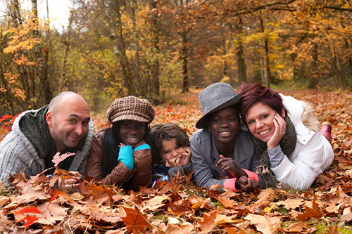 Family laying in the leaves with trees in background