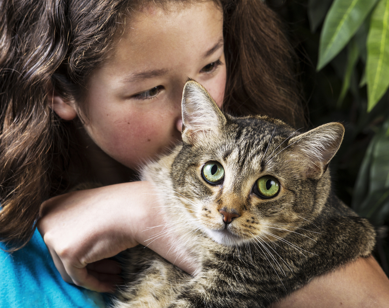 girl with her arms around a cat