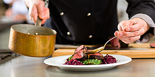 Chef adding sauce to a dish