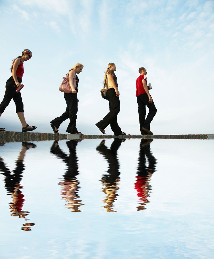 four people walking up the river