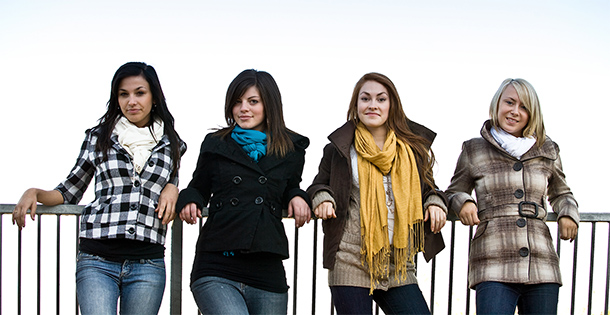 Four girls leaning on a railing