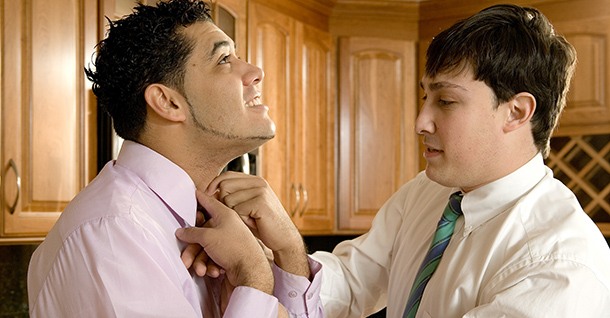 Two men tying a tie