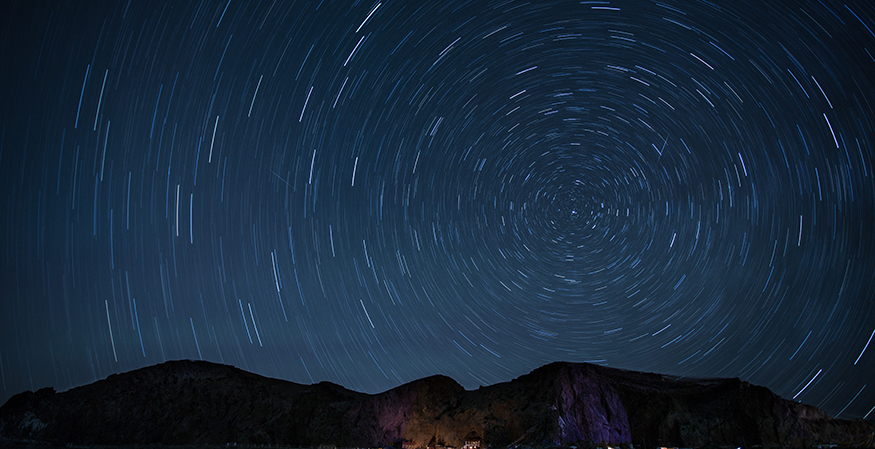 Time lapse photo of starts moving in a circular pattern throughout the night sky